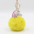 Detail of yellow plush unicorn keychain with gold metal ring and colorful leather accent - 8x12cm / Yellow