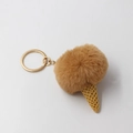 Detail of a brown plush ball ice cream keychain with yellow waffle cone and golden ring - Coffee