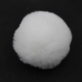 Dettaglio di un pompon di pelliccia sintetica bianca soffice per borse e portachiavi - Confezione da 8cm / Bianco