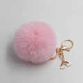 Detail of pink faux fur pompom keychain with golden metal clasp and rainbow charm - Light Pink