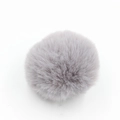 Dettaglio di un pompon in finta pelliccia grigio-viola chiaro con una consistenza soffice - Confezione da 8cm / Grigio chiaro