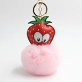 Detail view of a strawberry plush keychain with a soft pink faux fur ball and gold metal ring - Pink Strawberry