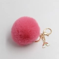 Detailed shot of a fluffy pink plush ball keychain with a gold lobster clasp and rainbow charm - Deep Pink