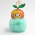 Makro-Detail von Cartoon-Orange aus Kunstleder mit mintgrünem flauschigem Plüsch-Schlüsselanhänger - Grüner Pfirsich