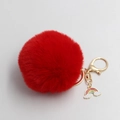 Detail of red fluffy plush ball keychain with golden clasp and rainbow cloud charm - Red