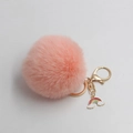 Detail of pink faux fur pompom keychain with golden clasp and rainbow cloud charm - Pink