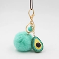 Dettaglio del portachiavi a pompon in finta pelliccia verde menta con ciondolo avocado e campanello - Verde Menta