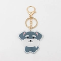 Detailed close-up of a cute acrylic schnauzer keychain with a gold lobster clasp - Grey Dog