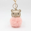 Détail du porte-clés pompon en peluche rose avec tête d'ours dorée et fermoir mousqueton - Rose