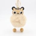 Detailed close-up of a tiger-themed faux leather and plush pompom keychain accessory - Light Coffee