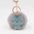 Détail d'un porte-clés pompon gris-violet avec breloque chat en acrylique bleu et crochet doré - Chat gris