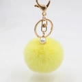 Nahaufnahme gelber Plüsch-Schlüsselanhänger mit goldenem Verschluss und Perlenverzierung - Bommel Durchmesser 6CM / Gelb