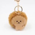 Detailansicht eines weichen braunen Plüsch-Pompons mit niedlichem Pudel-Acrylanhänger - Teddyhund