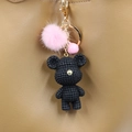 Handmade crochet bear keychain with pink fur ball and bell on leather bag strap - Black Bear