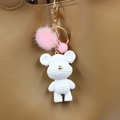 White knitted bear keychain with pink fur pom pom and gold metal clasp on leather bag - Polar Bear