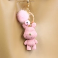 Detailansicht vom rosa Strickbär Schlüsselanhänger mit Plüschbommel an Ledertasche - Rosa Kaninchen