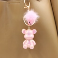 Close-up of pink pearlescent bear keychain with fluffy fur pompom on a leather bag - Pink Bear