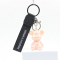 Detail of pearlescent pink bear keychain with Attitude is everything wrist strap - Pink