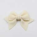 Close-up of a handmade beige fabric bow accessory for phone cases and shoes - Beige