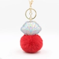 Detail of laser shell charm with a vibrant red faux fur pompom and gold metal clasp - Red