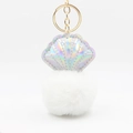 Detail of laser PU shell pendant with fluffy pom-pom and gold metal keychain loop - White