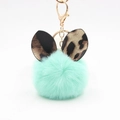 Detail of mint green plush pom pom keychain with leopard print ears and gold lobster clasp - Mint Green