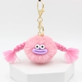 Pink furry monster keychain with purple sausage mouth and braids on white stand - Pink