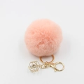 Close-up of pink faux fur pompom keychain with golden geometric crystal pendant - Pink