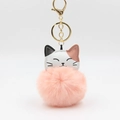 Detailed close-up of fluffy pink pom pom with tri-color leather cat face keychain charm - Pink