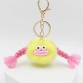Llavero de monstruo de peluche amarillo con labios rosados y trenzas en soporte blanco - Amarillo