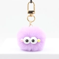 Détail du porte-clés pompon violet en peluche avec de grands yeux et crochet doré - Violet Clair