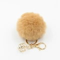 Detail view of a fluffy camel faux fur keychain with gold lobster clasp and crystal charm - Khaki