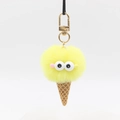 Detail eines gelben Plüsch-Eiscreme-Anhängers mit Kulleraugen und goldenem Verschluss - Gelb