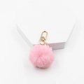 Vue détaillée du porte-clés pompon en fausse fourrure rose avec fermoir en métal doré - Rose