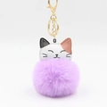 Close-up of a purple fluffy pompom lucky cat keychain with white and brown faux leather - Violet