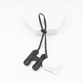 Close-up of black leather letter H and white heart charm pendant for handbags - White Black