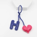 Detailed view of handmade blue leather H-letter and pink heart bag charm with fine stitching - Rose Pink And Sapphire Blue