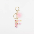 Détail du porte-clés lettre F en résine avec pompon rose et paillettes de cœur - Lettre F