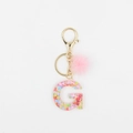 Détail du porte-clés lettre G en résine avec paillettes cœur et pompon en fourrure rose - Lettre G