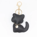 Détail du porte-clés chat en cuir noir avec chaîne dorée et étiquette ronde gravée - Porte-clés Noir