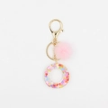 Détail du porte-clés pompon rose avec anneau en résine rempli de paillettes de cœur - Lettre O