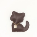 Gros plan d'un porte-clés chat en cuir marron avec chaîne dorée et pendentif gravé - Collier Marron