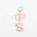 Détail du porte-clés lettre S en résine avec sequins cœurs et pompon en fourrure rose - S