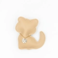 Détail de chaîne dorée avec pendentif gravé sur un porte-clés chat en cuir abricot - Collier Kaki