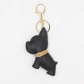 Dettaglio ravvicinato di un portachiavi a forma di cane in pelle PU nera con finiture oro - Con fibbia / Nero