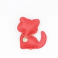 Détail du pendentif chat en cuir rouge avec coutures soignées et plaque dorée gravée - Collier Rouge