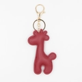 Detailed close-up of a red leather giraffe keychain with gold metal hardware and stitching - With Keychain / Burgundy