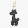 Detailed view of the black textured PU leather giraffe charm with gold hardware - With Keychain / Black