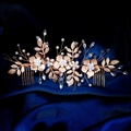 Detalle del peine de novia dorado con flores de esmalte y perlas sobre seda azul oscuro - Dorado