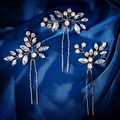 Detail of three gold leaf-shaped U-shaped hair pins with shimmering rhinestones on blue silk - Gold Style (HS-J6405G)